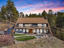 Charming two-story home with a brown roof, blue siding and a fenced yard perfect for outdoor entertaining at 4948 Cameyo Rd, Indian Hills, CO 80454