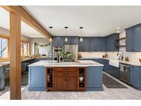 Open kitchen featuring blue cabinets, a large center island, and stainless steel appliances at 4948 Cameyo Rd, Indian Hills, CO 80454