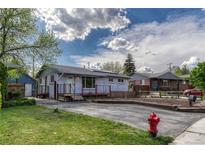 Charming single-story home featuring a well-maintained lawn and a welcoming front porch with solar panels above at 7541 Julian St, Westminster, CO 80030