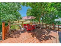 Inviting outdoor deck featuring a dining set with a red and white striped umbrella at 6085 S Parfet St, Littleton, CO 80127