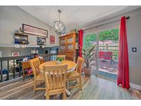 Bright dining room with wood table, deck access, and stylish light fixture at 6085 S Parfet St, Littleton, CO 80127