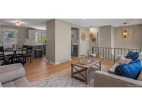 Inviting living room seamlessly connects to the kitchen with modern decor and hardwood floors, bathed in natural light at 9598 Lou Dr, Northglenn, CO 80260
