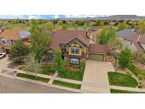 Stunning exterior view of a well-maintained home with lush landscaping and a three-car garage at 15258 W 75Th Pl, Arvada, CO 80007