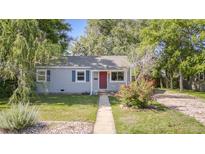 Inviting single-story home with lush landscaping, a well-manicured lawn, and a charming front walkway at 2260 Lilly Dr, Thornton, CO 80229
