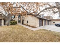 Inviting exterior of brick home with a three-car garage and mature landscaping at 7250 Eastmoor Dr # 105, Denver, CO 80237
