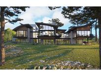 Modern home featuring large windows, balconies, and a beautifully landscaped lawn at 7935 Dante Dr, Littleton, CO 80125