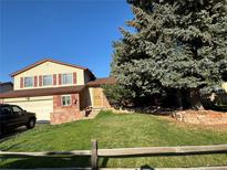 Inviting two-story home with a well-manicured lawn and mature trees at 1824 S Granby St, Aurora, CO 80012