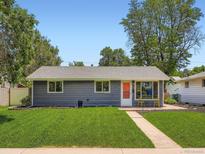 Charming single-story home with a well-manicured lawn and inviting orange front door at 3750 S Galapago St, Englewood, CO 80110