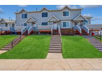 Inviting townhome with a well-manicured lawn and charming staircases leading to each front door at 4120 E 119Th Pl # B, Thornton, CO 80233