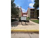 Inviting condo complex with manicured landscaping, mature trees, and a clear sign for easy navigation at 14852 E Kentucky Dr # 934, Aurora, CO 80012