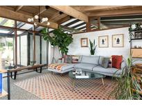 Sunken living room with exposed beam ceiling, modern decor, and bright natural light at 3605 W Berry Ave, Littleton, CO 80123