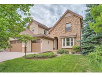 Two-story stone home with landscaped yard and attached garage at 9850 Sunset Hill Circle Cir, Lone Tree, CO 80124