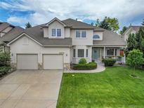 Inviting home with a well-manicured lawn, three-car garage and a charming covered porch, perfect for relaxing outdoors at 14878 E Aberdeen Ave, Centennial, CO 80016