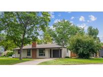 Charming single-story home with a brick chimney, attached garage, and well-manicured lawn at 1420 S Leyden St, Denver, CO 80224