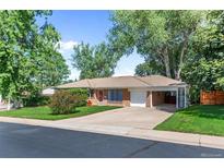Charming single-story home with a well-maintained front yard, driveway, and attached garage at 420 Dudley St, Lakewood, CO 80226