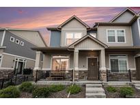 Charming townhouse featuring stone accents, covered porch, and landscaped front yard at 20000 E 40Th Ave # 4, Denver, CO 80249