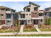 Beautiful, modern townhome featuring gray stucco and brick, plus balconies and landscaped front yards at 4535 W 50Th Ave, Denver, CO 80212