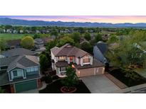 Charming two-story home featuring a well-manicured lawn, lovely landscaping, and mountain views at 9948 Silver Maple Rd, Highlands Ranch, CO 80129