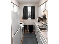Functional kitchen features white appliances, ample cabinet space, and a bright window at 3626 S Granby Way # L03, Aurora, CO 80014