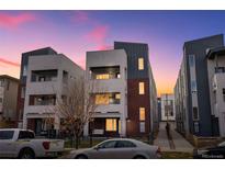 Modern townhome showcasing brick and stucco exterior, with a grey roof, and a cozy porch swing at 1733 Irving St # 101, Denver, CO 80204