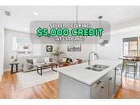 Bright and airy living room showcasing modern gray tones, beautiful hardwood floors, and ample natural light at 1733 Irving St # 101, Denver, CO 80204