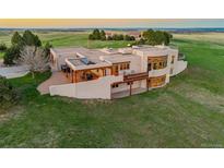 Stunning exterior elevation showcases a modern stucco home with a deck, hot tub, and scenic views in the countryside at 1764 Mesa Ridge Ln, Castle Rock, CO 80108