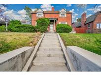 Charming brick home featuring lush landscaping and a welcoming front entrance with concrete stairs at 3070 Colorado Blvd, Denver, CO 80207