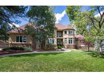 Charming home with stone accents, manicured lawn, and mature trees on a sunny day at 5170 Pinyon Jay Rd, Parker, CO 80134