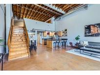 Inviting living room with open floor plan, staircase, modern kitchen, and abundant natural light at 2715 Blake St # 2, Denver, CO 80205