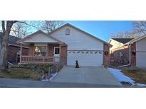 Ranch style home with attached garage and landscaped yard at 6567 Pierson St, Arvada, CO 80004