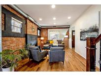 Inviting living room featuring exposed brick, hardwood floors, and recessed lighting at 3233 W 29Th Ave, Denver, CO 80211