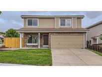 Two-story home featuring a stone facade, tan siding, and a well-manicured lawn at 3853 Orleans Ct, Denver, CO 80249