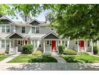 Charming townhome with a well-maintained lawn, inviting porch, and bright red door at 4395 E Jewell Ave # 3, Denver, CO 80222