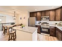 Well-lit kitchen features stainless steel appliances, granite countertops, and dark cabinetry with a center island at 3578 Tranquility Trl, Castle Rock, CO 80109