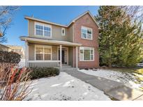 Two-story brick home with a front porch and landscaped yard at 12454 Knox Ct, Broomfield, CO 80020