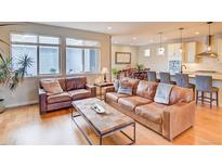 Cozy living room featuring hardwood floors, natural light, and comfortable seating arrangements at 15818 W 95Th Ave, Arvada, CO 80007