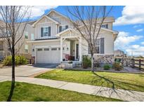 Charming two-story home boasts beautiful stone accents, a well-manicured lawn, and a two-car garage at 24222 E Canyon Pl, Aurora, CO 80016