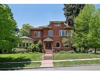 Stately brick home with lush green lawn and mature trees, offering classic elegance and curb appeal at 685 N Emerson St, Denver, CO 80218