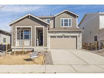 Charming two-story home with a front porch, two-car garage, stone accents and craftsman-style details at 24789 E 39Th Ave, Aurora, CO 80019
