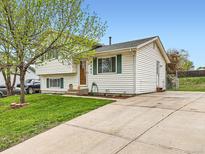 Charming two-story home featuring white siding, green shutters, a well-manicured lawn and a driveway at 8267 High St, Denver, CO 80229