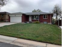 Charming single-story brick home featuring an attached garage and well-maintained front lawn at 1152 S Eaton St, Lakewood, CO 80232