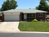 Charming one-story brick home with an attached garage, well-manicured lawn and inviting curb appeal at 1152 S Eaton St, Lakewood, CO 80232