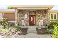Inviting ranch home exterior with stone accents and a charming front porch at 1155 S Balsam St, Lakewood, CO 80232