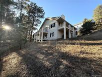 Spacious home with multi-tiered balconies and nestled among mature trees at 22148 Red Hawk Ln, Golden, CO 80401