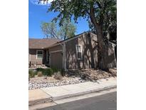 Charming home exterior with attached garage, low maintenance landscaping, sidewalk, and mature tree at 14141 E Baltic Pl, Aurora, CO 80014