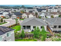 View of a well-maintained gray home, surrounded by lush greenery and a vibrant neighborhood with mountain views in the background at 1465 Gentle Rain Dr, Castle Rock, CO 80109