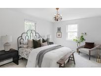 Bright bedroom featuring a decorative chandelier, cozy seating, and large windows for ample natural light at 6982 Estes Dr, Arvada, CO 80004
