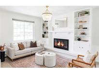 Bright living room boasts a cozy fireplace, built-in shelves, and stylish decor at 6982 Estes Dr, Arvada, CO 80004