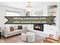 Bright living room featuring a fireplace, sofa, decor, and a contemporary chandelier at 6982 Estes Dr, Arvada, CO 80004