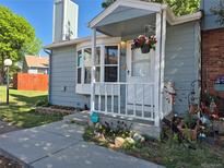 Charming home exterior featuring a cozy front porch, well-manicured lawn, and vibrant flower displays at 8168 Washington St # 46, Denver, CO 80229